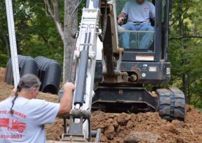 Picture of a Bobcat machine with J & J Septic & Sewer team