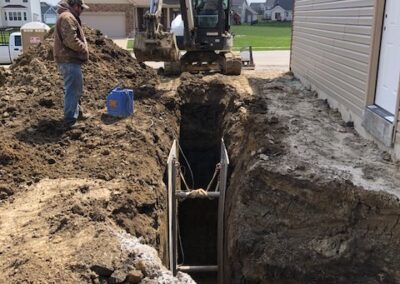 Bobcat machine is working on the path clearing making trench